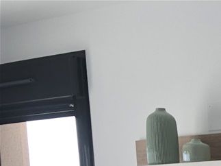 Utgång till balkongen till vänster om tv-möbeln mitt emot soffan.