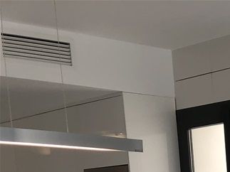 Vardagsrummet med matplats och en glimt av köket med dess öppna planlösning.